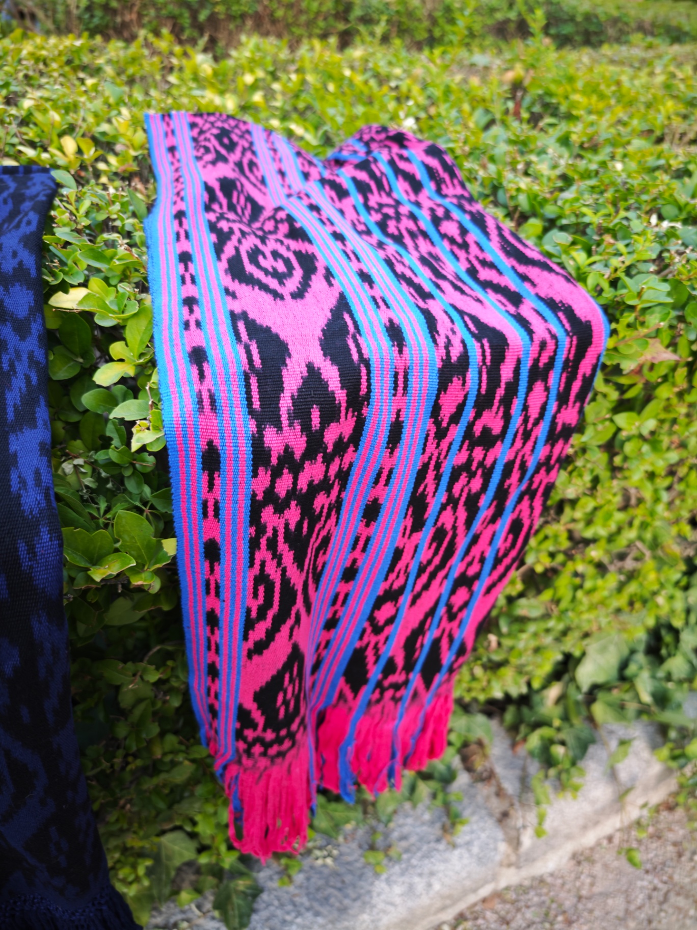 Detalle del ikat fucsia y azul con guardas geométricas y flecos anudados