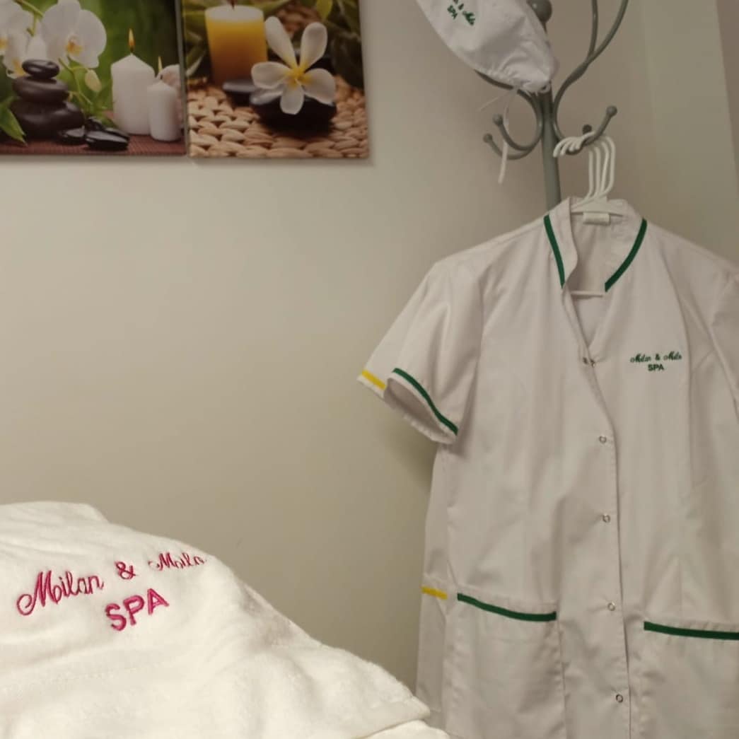 Uniforme de trabajo blanco con bordado corporativo y ribetes verdes