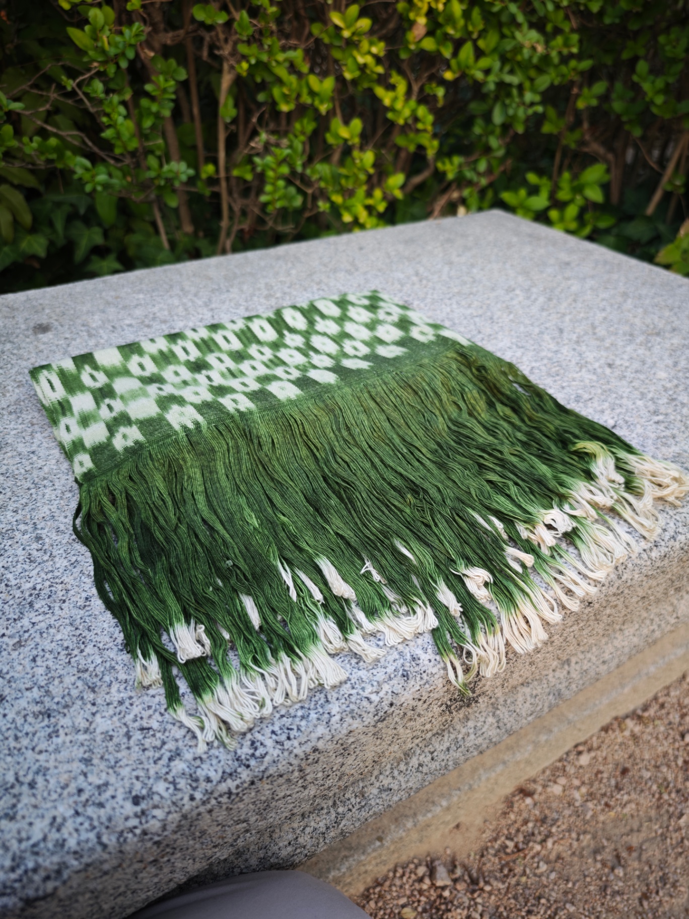 Detalle de flecos en degradado verde y marfil de la bufanda ikat verde jade