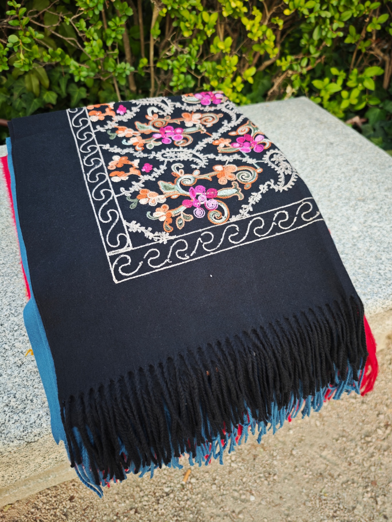 Bufanda de cashmere negro con bordado floral multicolor y greca de arabescos marfil, flecos negros