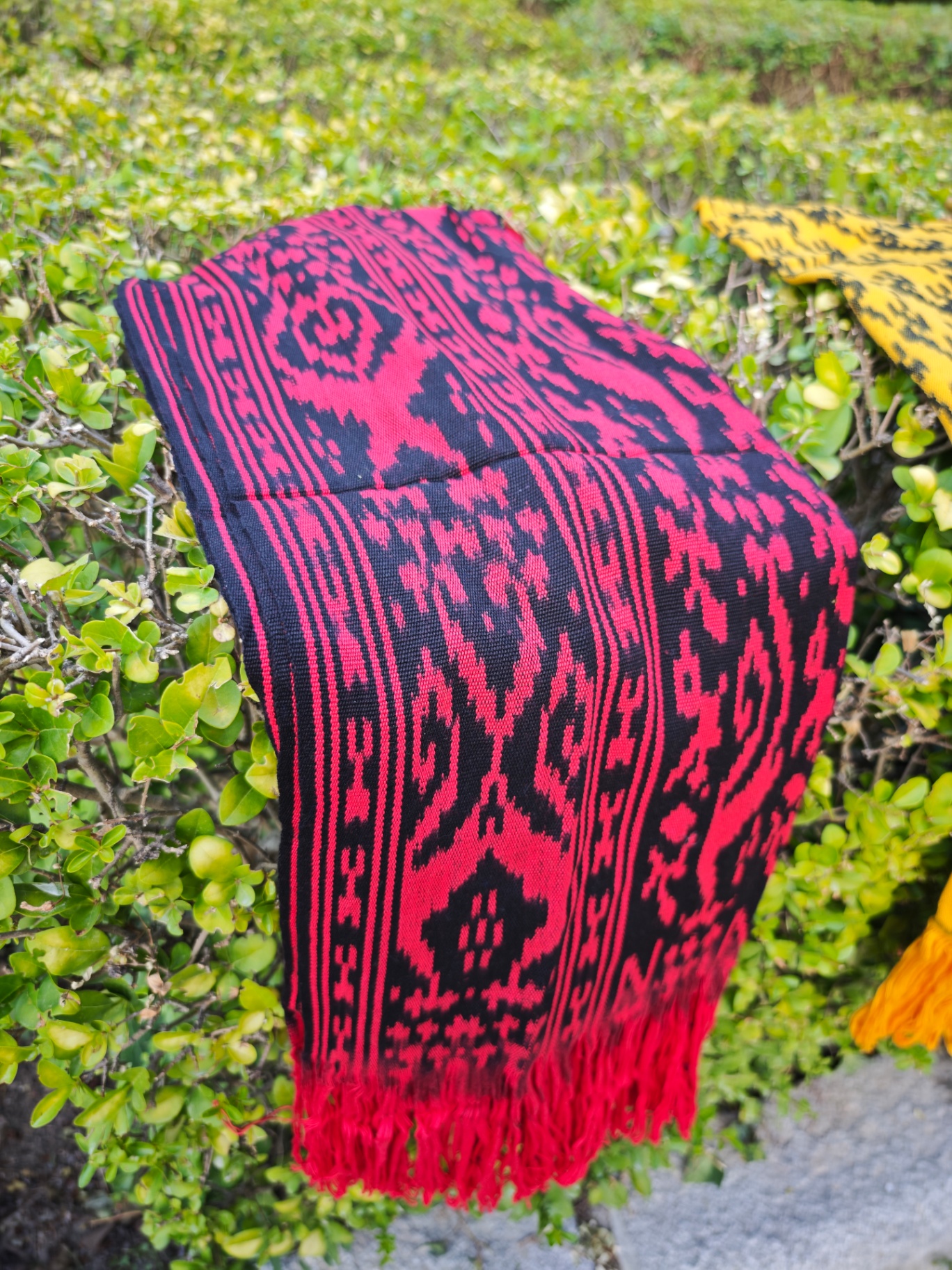 Bufanda ikat rojo carmín y negro con motivos geométricos y flecos rojos