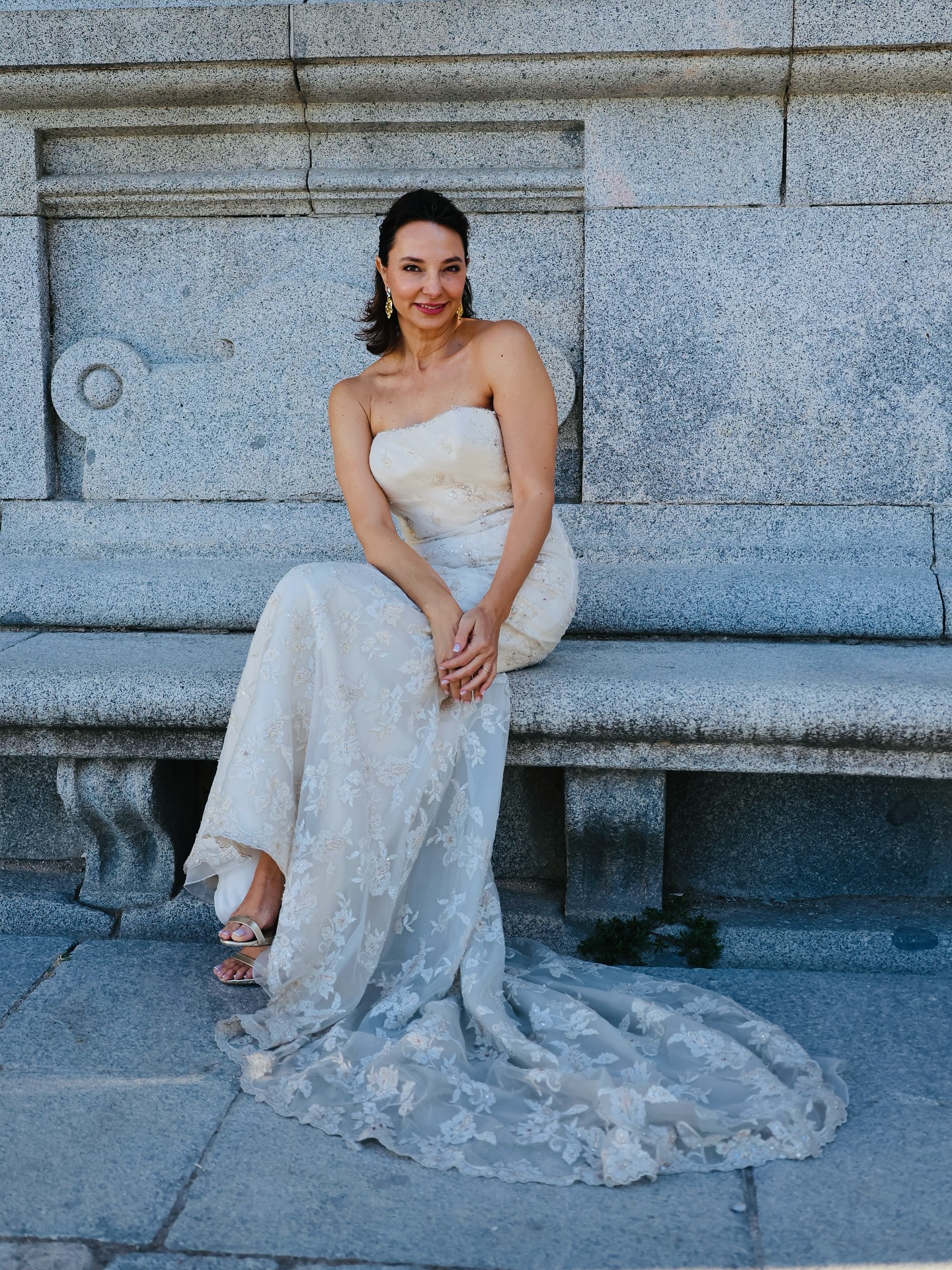 Novia sentada con vestido a medida de encaje y pedrería