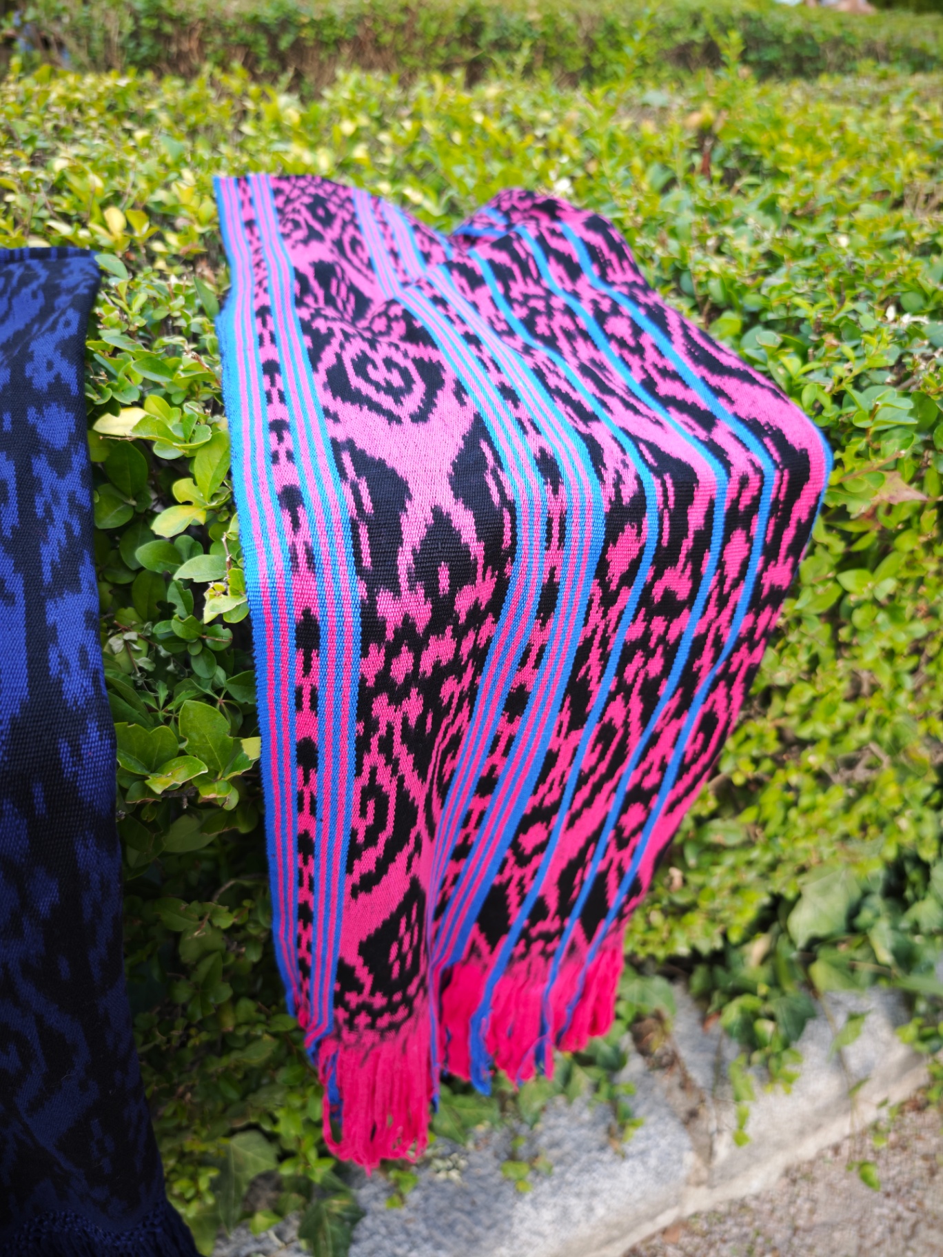 Bufanda ikat fucsia y azul cobalto con motivos negros y flecos, tejida a mano