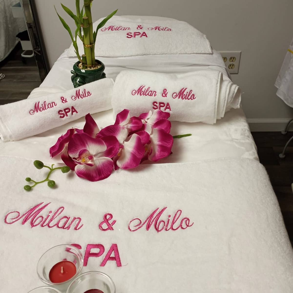 Toallas blancas bordadas con logo Milan & Milo SPA en hilo fucsia