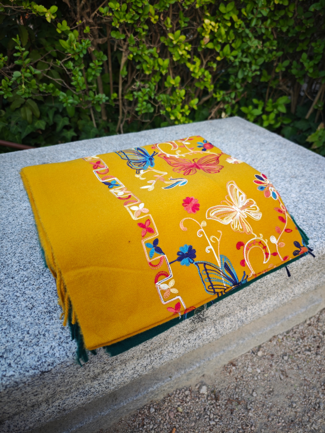 Bufanda de cashmere mostaza con bordado de mariposas y flores multicolor y cenefa geométrica lateral